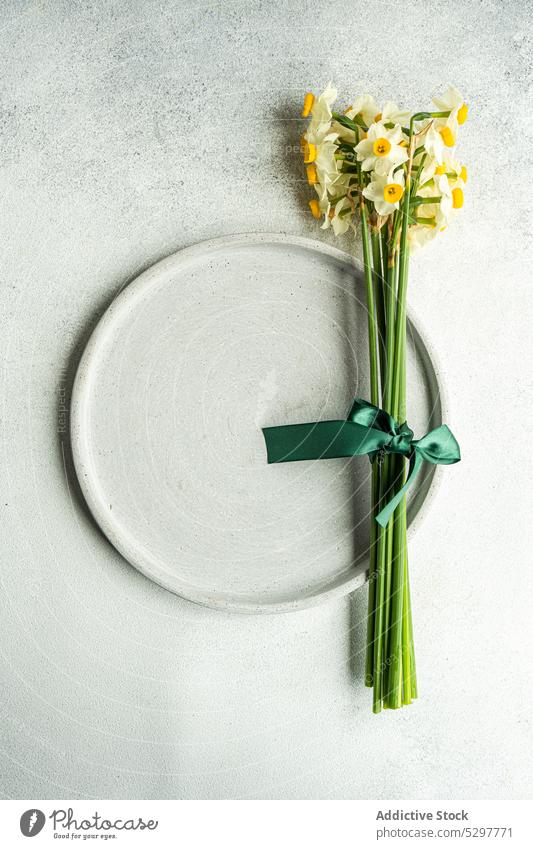 Spring table setting with daffodils buld ceramic concrete cutlery dinner dinnerware festive floral flower food holiday Easter narcissus narcisus petal place