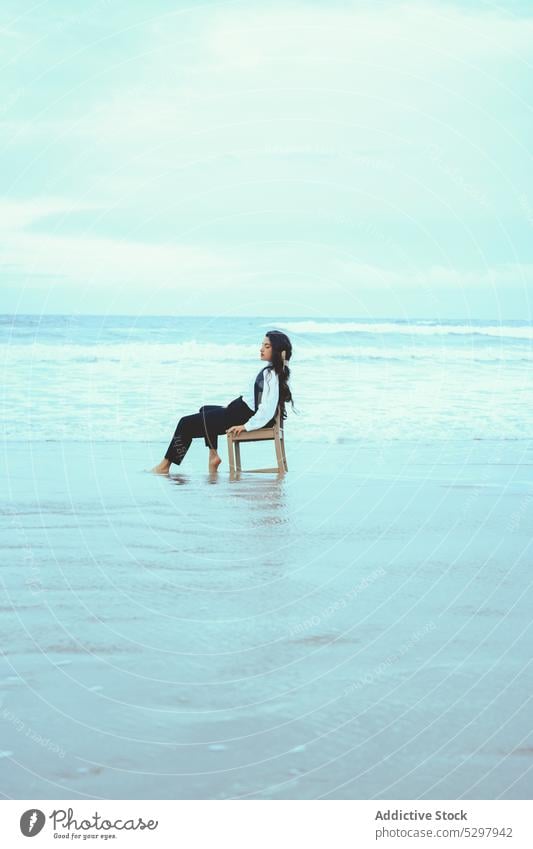 Calm woman with closed eyes on chair near sea beach seashore sand seaside relax rest calm coast young ocean female peaceful style water eyes closed resort