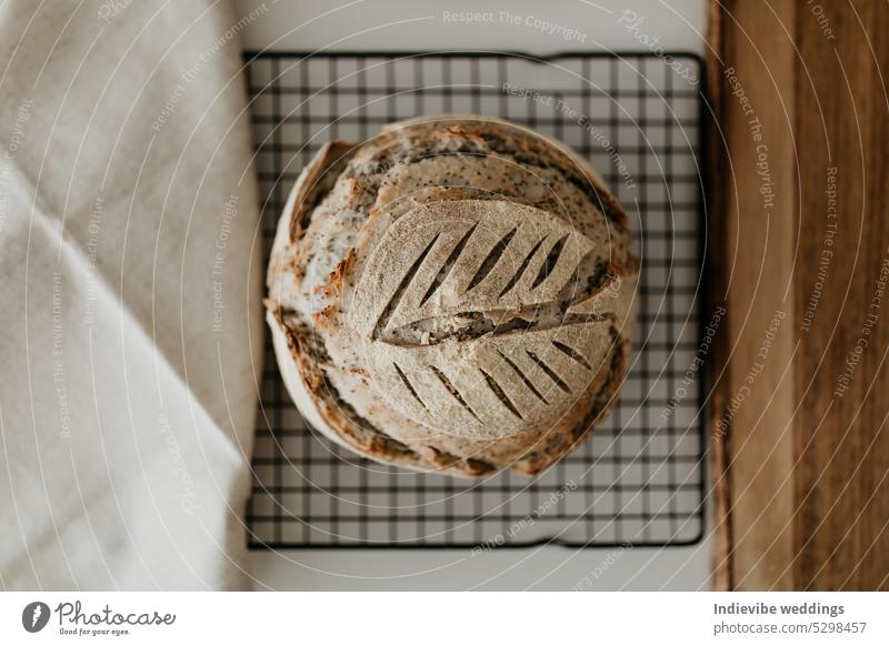 Sourdough bread. Homemade loaf on cool rack. Softly blurred white background. Cozy flat lay with wooden chopping board and linen napkin sourdough home made