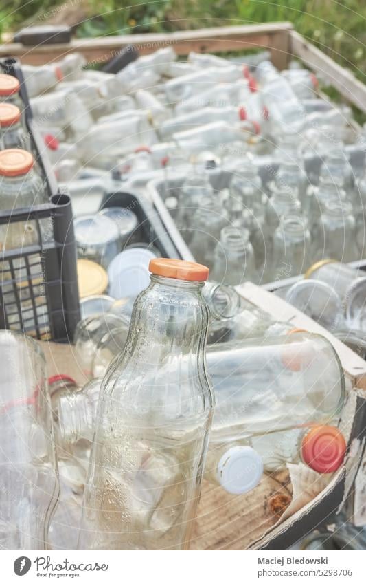 Various various types of empty glass bottles stored in containers for recycling, selective focus. dirty waste trash drink recycle used garbage industry