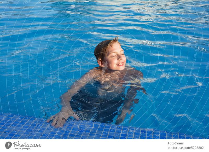 A boy in the swimming pool laughing Sunny Copy Space Teenager Joy Water Day Vacation movement Boy Active Pool athletic Summer Sport child health Travel