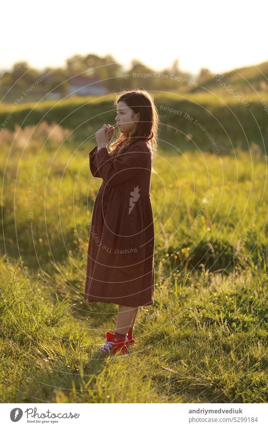 lovely cute little girl playing outdoors at sunset, walking and having fun, happy childhood. summer sunny holiday beautiful nature field green people grass park