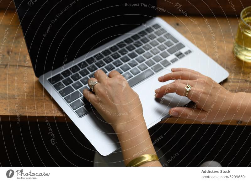 Unrecognizable woman working on laptop during remote project in cafe freelance workplace tea planner female table vietnam device gadget distance busy browsing