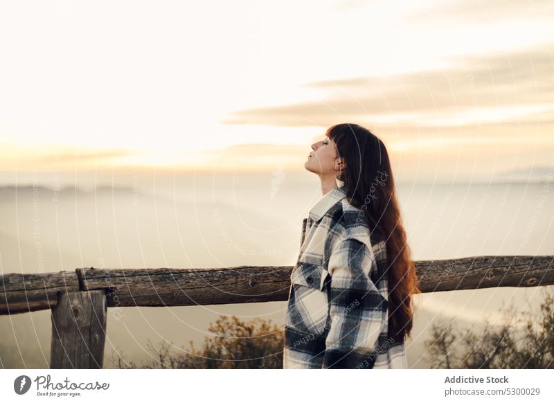 Dreamy woman standing near wooden fence in nature sunset traveler sky pensive thoughtful calm rest spain female trip vacation almatret catalonia tourist young