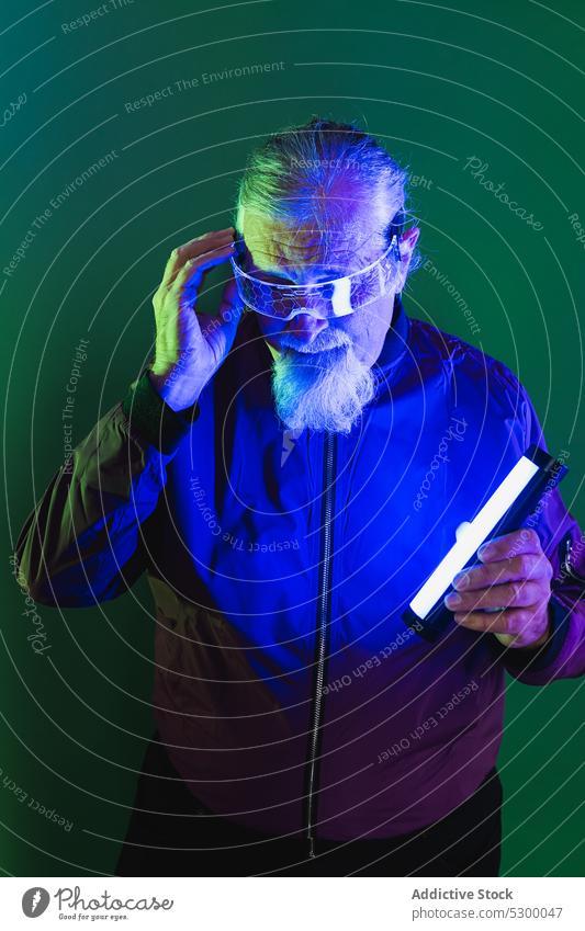 Amazed elderly man with neon light hipster surprise amazed touch head beard style glasses shock male casual senior pensive astonish wonder serious gesture