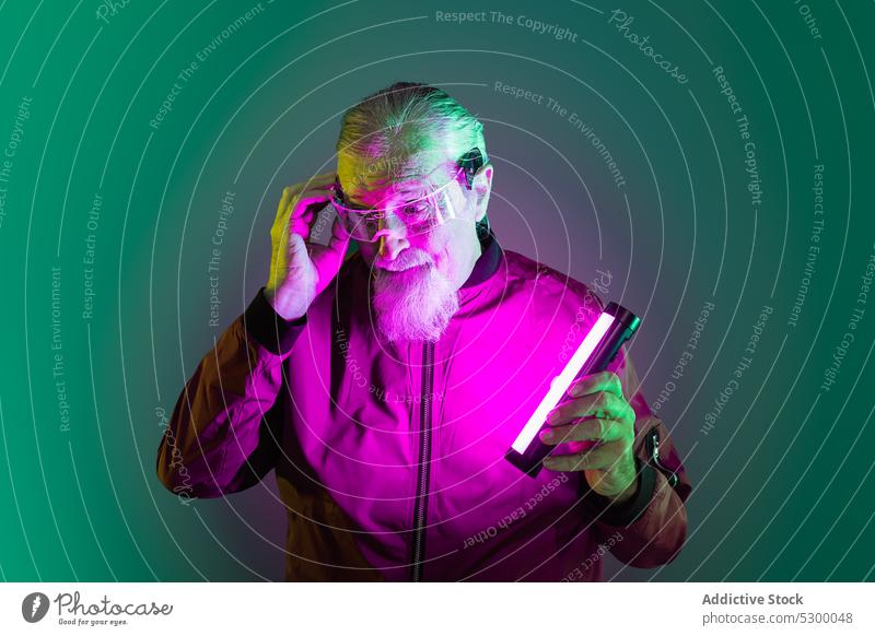Amazed elderly man with neon light hipster surprise amazed touch head beard style glasses shock male casual senior pensive astonish wonder serious gesture