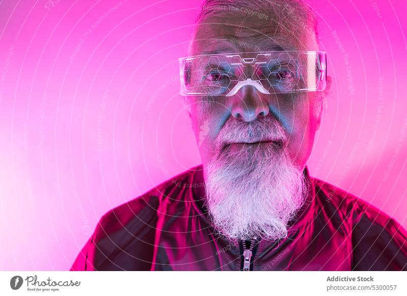 Confident senior man in glasses neon hipster beard portrait serious style confident illuminate male elderly light pensive mature bright modern green glow