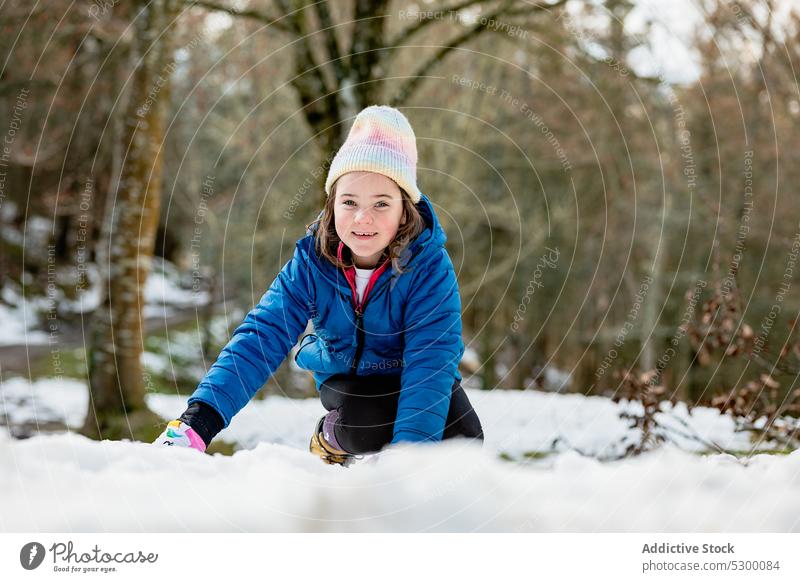 Cheerful girl playing with snow forest smile winter happy warm clothes nature cold kid child outerwear cheerful season hat joy fun frost woods childhood weather