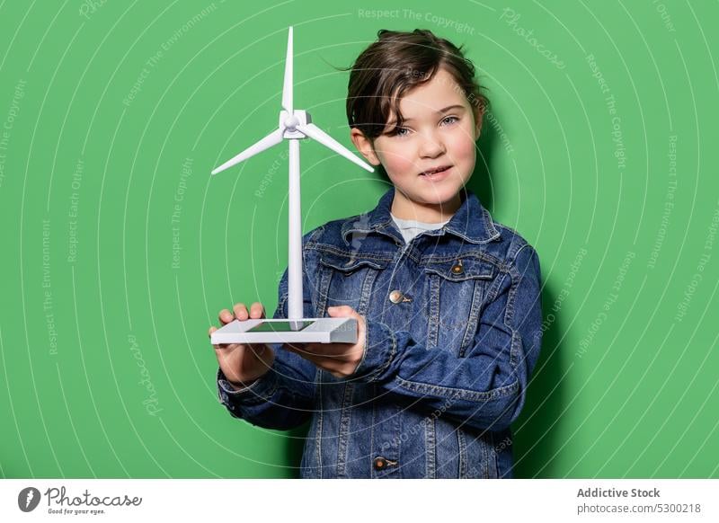 Smiling kid with windmill mockup girl child happy power energy eolic generator preteen focus casual cheerful smile joy childhood positive excited generation