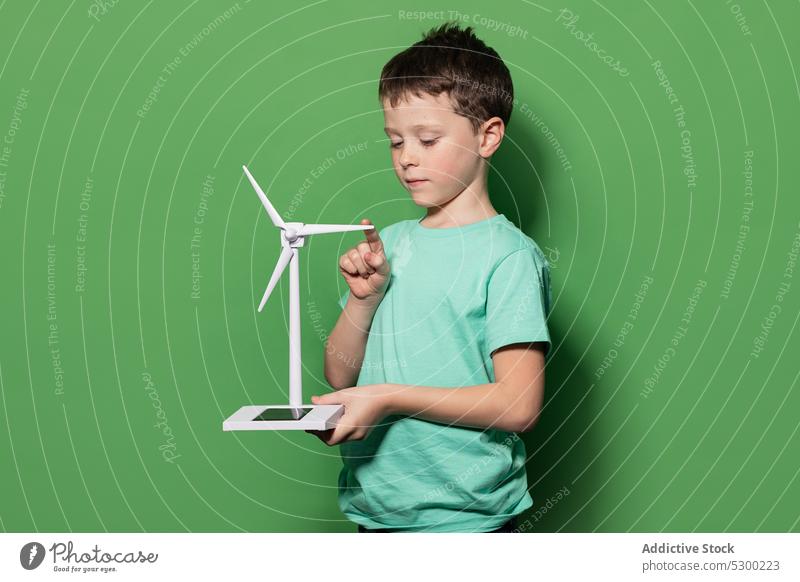 Smiling kid with windmill mockup boy child power energy eolic generator preteen focus casual renewable alternative energetics childhood positive excited