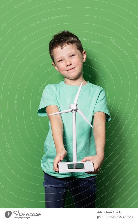 Smiling kid with windmill mockup boy child happy power energy eolic generator preteen focus casual cheerful smile glad joy childhood positive delight excited