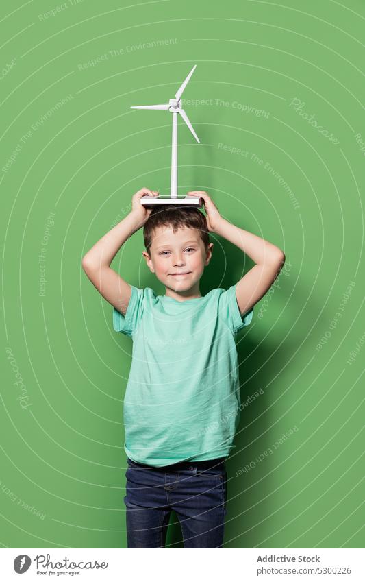 Smiling kid with windmill mockup on head boy child happy power energy eolic generator preteen casual cheerful smile joy childhood positive excited generation