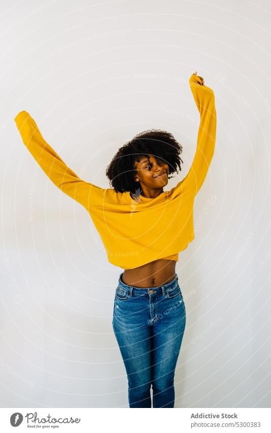 Positive black woman in casual outfit on white background belly appearance positive afro content cheerful smile happy hairstyle female african american young