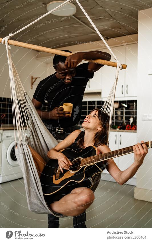Cheerful woman playing guitar with boyfriend couple musician weekend guitarist smile positive drink acoustic instrument together melody relax girlfriend