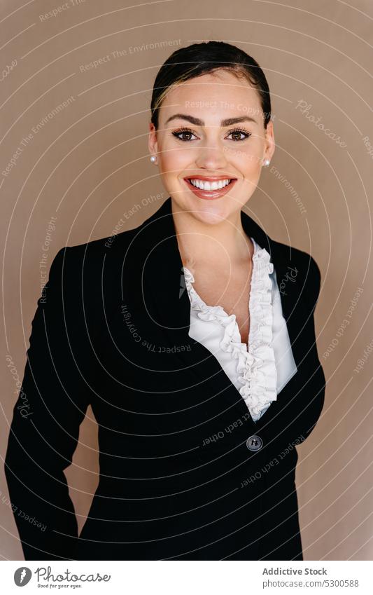 Diligent businesswoman in formal suit standing on fabric backdrop manager diligent toothy smile studio shot respectable hands clasped pleasant well dressed