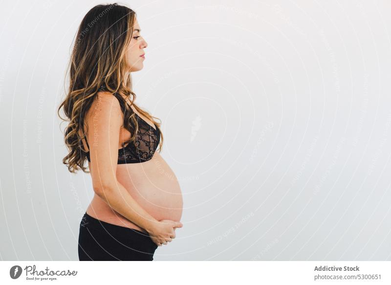 Crop pregnant woman touching tummy - a Royalty Free Stock Photo from  Photocase