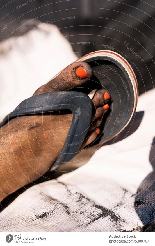 Crop dirty female foot in flip flops woman pedicure leg summer footwear daytime nail orange bright nail polish sahara mauritania africa toe shoe sandal sunlight