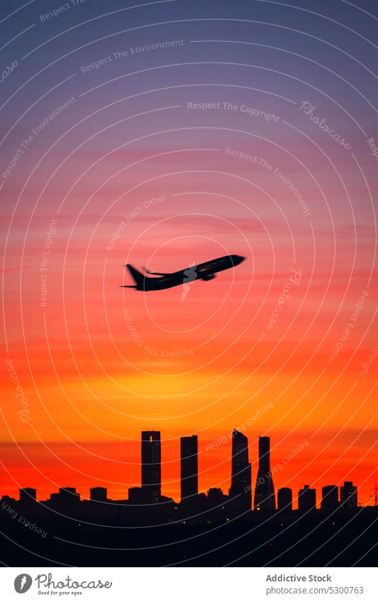 Plane flying over city buildings sunset plane silhouette sky cityscape architecture sundown madrid cuatro torres four towers twilight spain airplane aviation