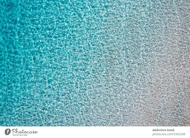 Textured background of transparent rippling sea water ripple texture sand surface turquoise abstract clean spain blue shore menorca cala macarella cala turqueta