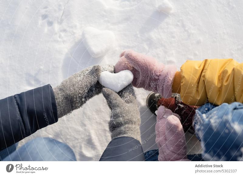 Unrecognizable kids with heart shaped snowball winter children hand play love nature frozen cold symbol romantic people environment wintertime ground snowflake