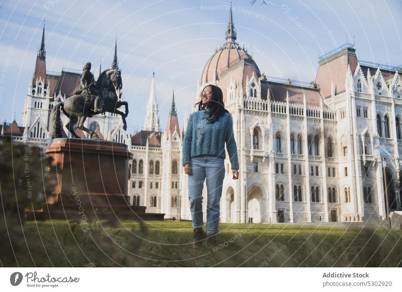 Happy woman standing on old city lawn building cathedral sightseeing architecture cheerful happy journey travel style budapest hungary structure casual town