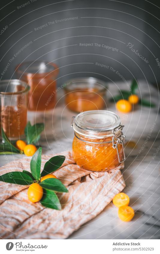 Glasses of kumquat jam with fruits fig jar fresh healthy glass table vitamin natural citrus nutrition ingredient diet food delicious tasty vegetarian closeup