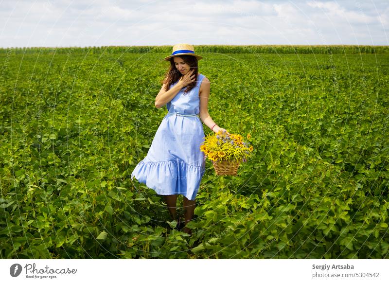 Beautiful girl with straw hat stands on a green meadow with a bouquet of flowers Woman Life Healthy Summer Nature Dress Flower Happy Spring Beauty & Beauty