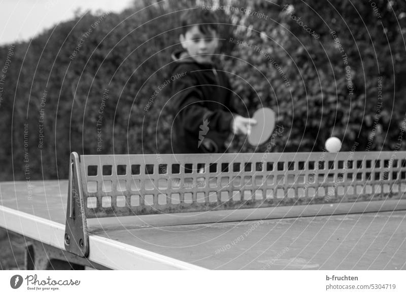 Child playing table tennis Table tennis Table tennis table table tennis table Leisure and hobbies Playing Ball game Sports Ball sports Joy black-and-white Day