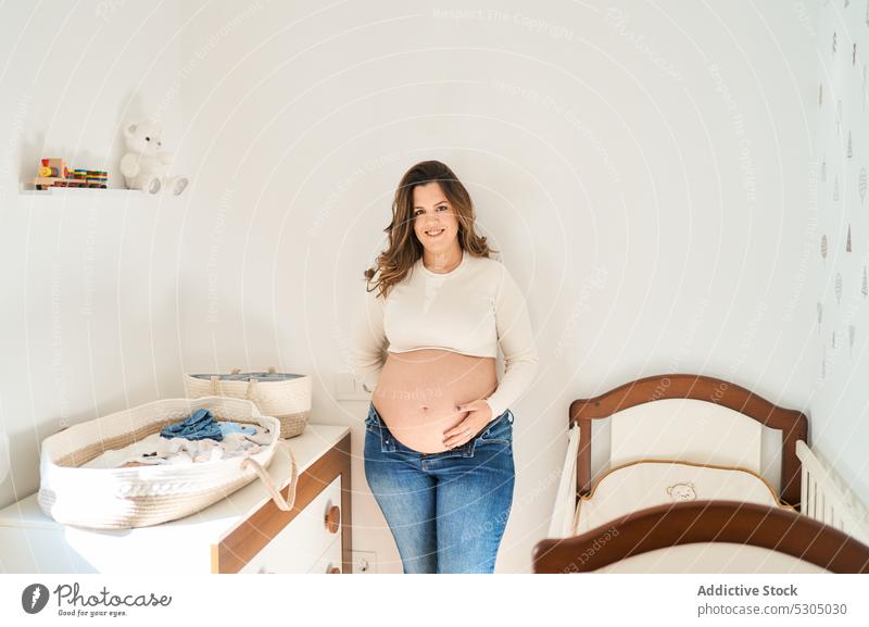 Happy expecting woman touching belly pregnant maternal happy relax nursery female pregnancy await childbearing prenatal motherhood anticipate parenthood mom