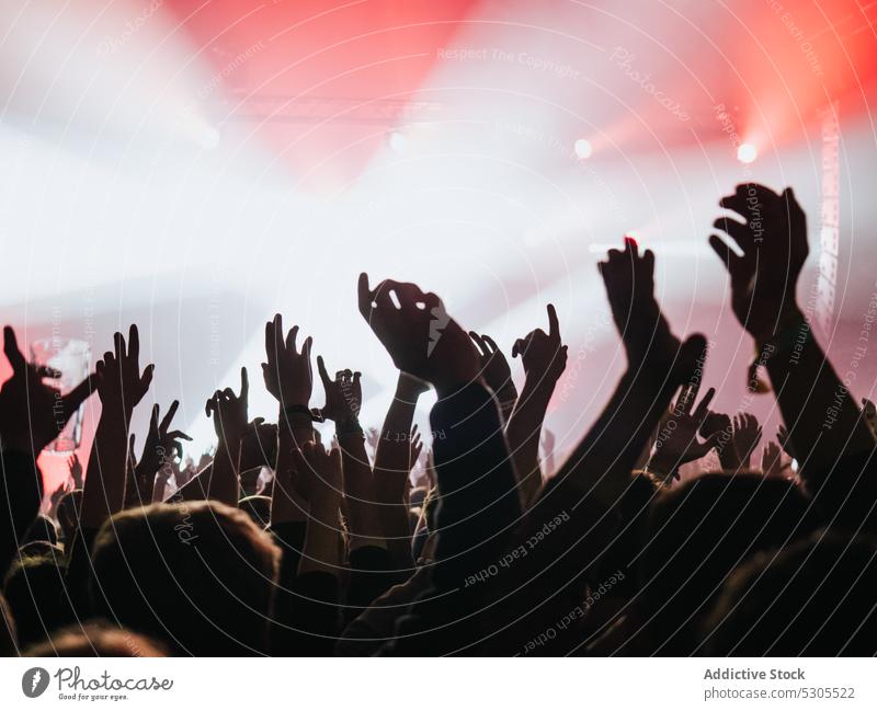 Hands of people on music show crowd raised hands concert red light illumination party audience festival nightlife event entertainment performance fan club sound