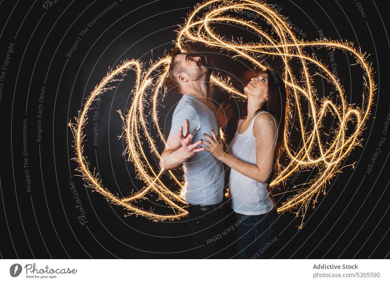 Couple near traces of light couple embraces young man woman casual love relationship together boyfriend trails hugging yellow bright vivid vibrant girlfriend