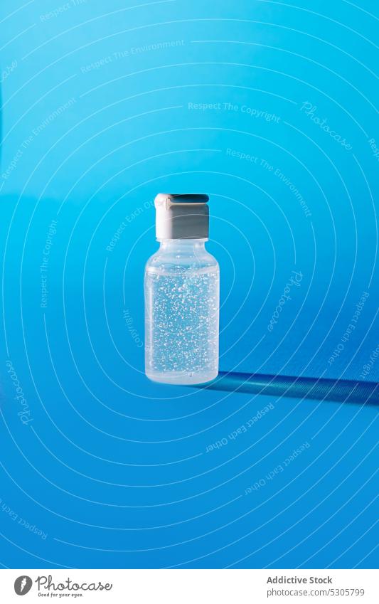 Transparent bottle of facial gel on blue background container bubble cosmetic product transparent plastic hygiene clean clear translucent pure natural skin care
