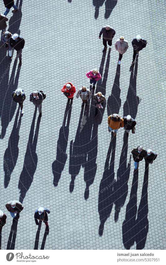 large group of people walking around the city, Bilbao city, basque country, spain crowd tourists tourism person human pedestrians shadow silhouette street