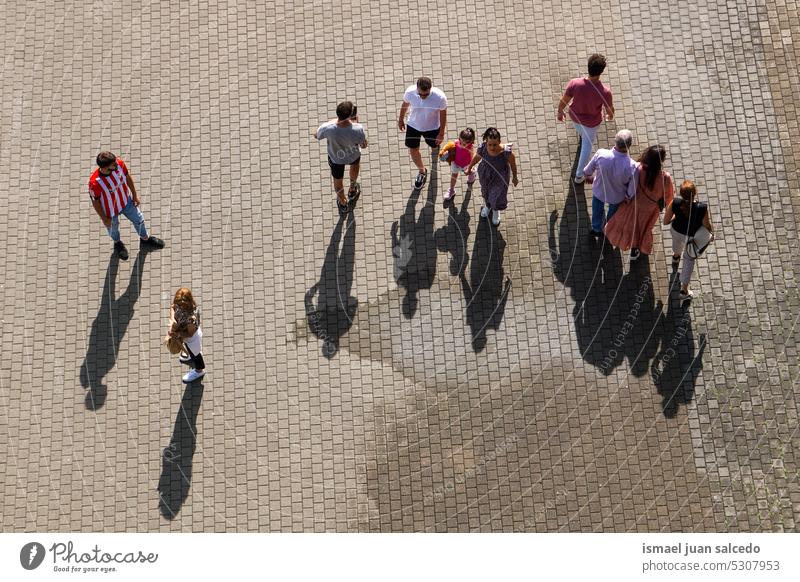 large group of people walking around the city, Bilbao city, basque country, spain crowd tourists tourism person human pedestrians shadow silhouette street