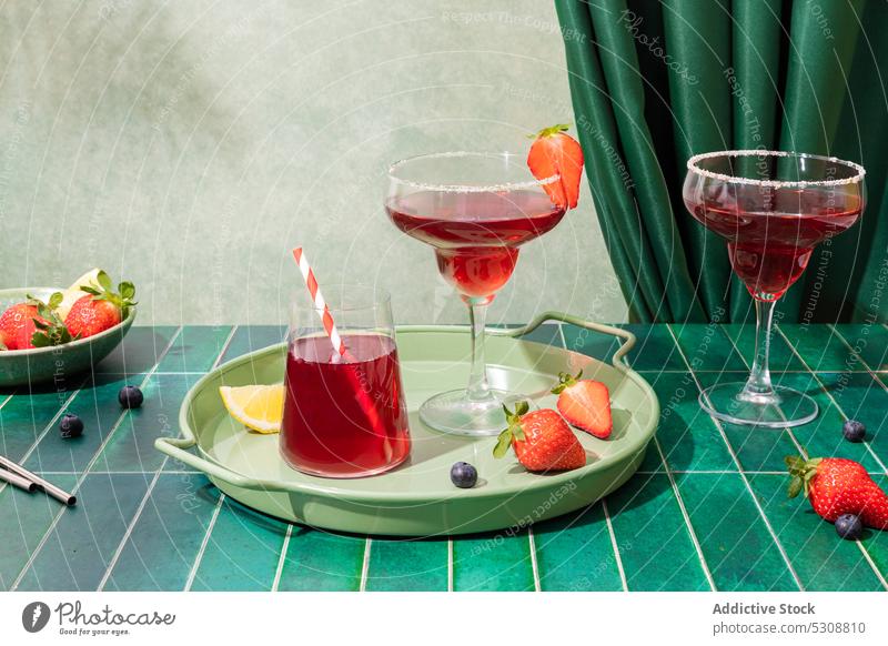 Strawberry cocktails with berries on tray alcohol strawberry glass drink refreshment lemon serve bar beverage summer delicious slice table cold red sweet tasty