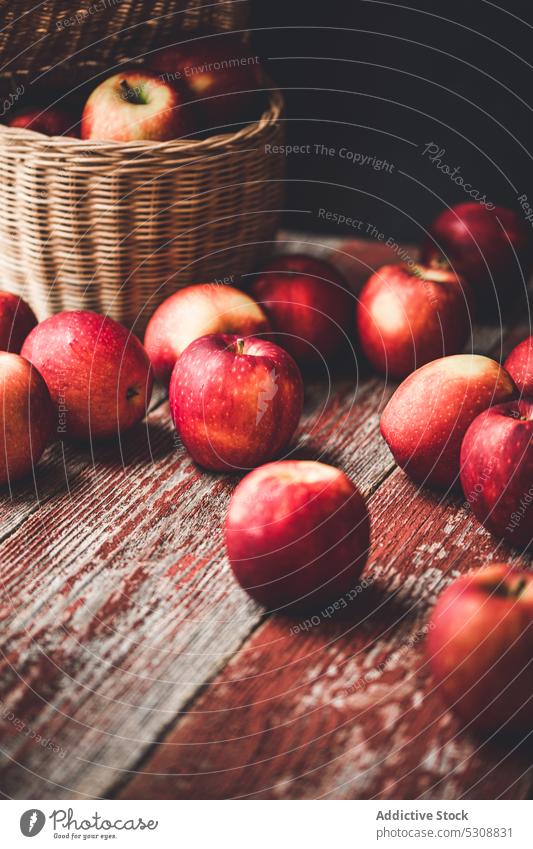 Wicker basket with ripe apples on wooden cupboard harvest natural countryside fruit shabby wicker food organic rustic vitamin fresh timber rural house red