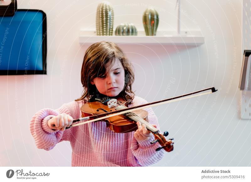 Cute child practicing violin in bedroom girl play music skill childhood talent musician adorable instrument fiddlestick melody string kid brunette casual