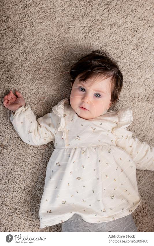 Cute little girl lying on carpet adorable floor child toddler calm rest dress kid cute childhood charming home sweet tranquil curious peaceful gentle carefree