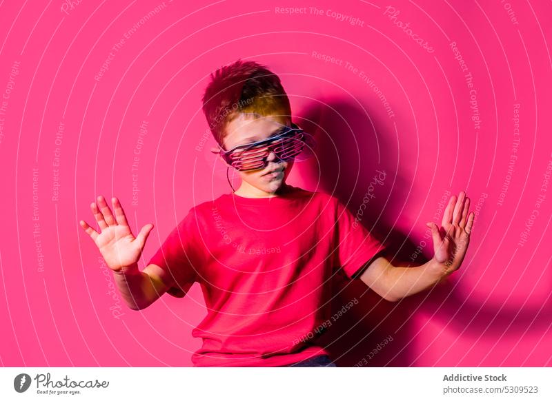 Serious boy in futuristic glasses looking at camera style kid colorful confident bright modern serious child vivid shirt vibrant trendy outfit neon personality
