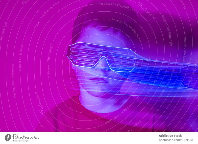 Serious boy in futuristic glasses looking at camera style kid colorful confident bright modern serious child vivid shirt vibrant trendy outfit neon personality