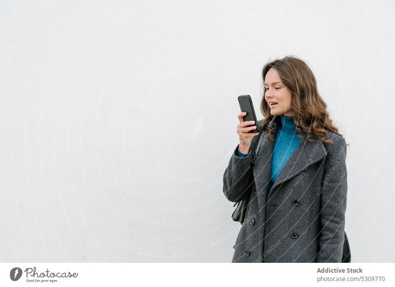 Woman recording voice message on mobile phone on white background woman smartphone using happy coat gadget device cellphone speak audio female conversation talk