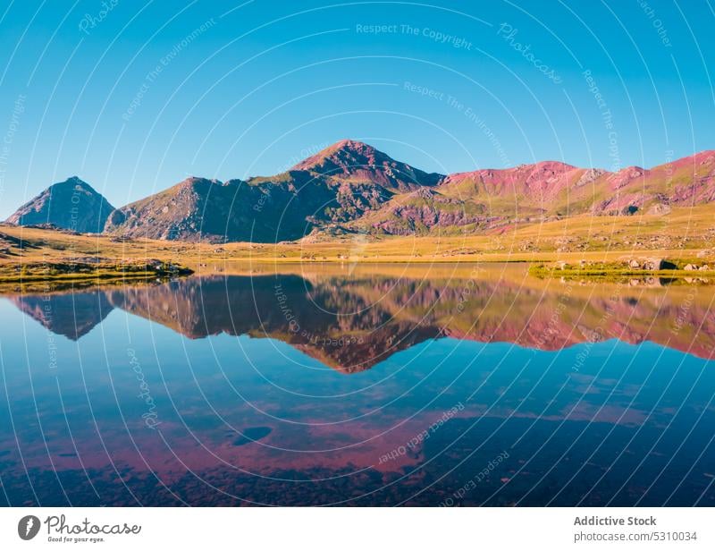 Calm lake surrounded by mountains nature landscape range sunset highland ridge calm scenic picturesque scenery anayet pyrenees huesca spain cloudless grass