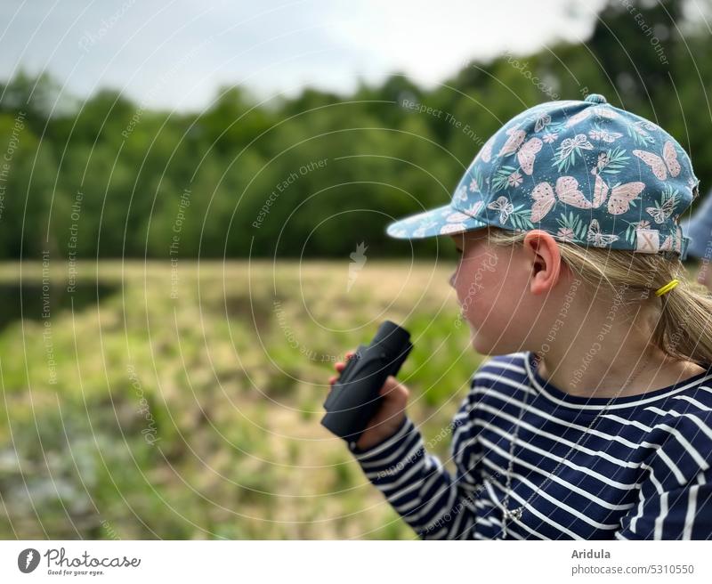 Child watching nature and holding binoculars in hand Girl Nature Observe Binoculars Infancy Exterior shot Looking Human being Curiosity Discover Peaked cap