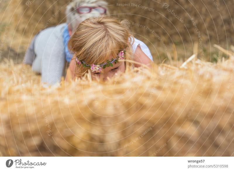 The search for the needle in the haystack continues topic day Needle in a haystack Straw Bale of straw Child Girl Exterior shot Summer Proverb Search action