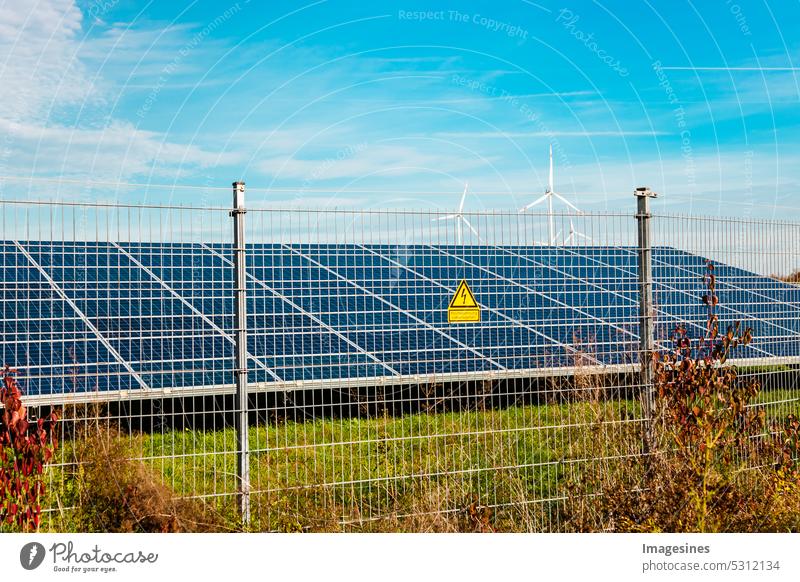 Agrophotovoltaics. High voltage danger to life. Warning sign on fence. Solar power plant. Panels in the field. Photovoltaics, alternative power source. Concept of sustainable resources