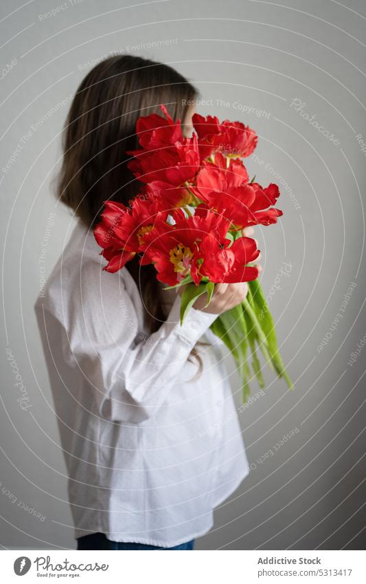 Unrecognizable woman standing with bouquet of amaryllis flowers flora plant blossom bloom stem concept floral delicate fresh red tender romantic young female