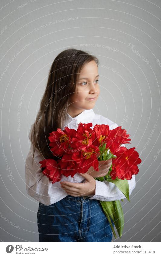 Girl standing with red tulips in room girl flower bloom joy show bouquet preteen appearance happy blossom young expressive present bunch style female plant gift