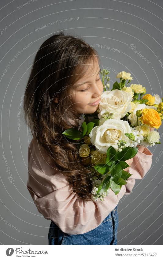 Preteen girl smelling bunch of flowers bouquet floral aroma bloom eyes closed blossom preteen natural female casual present romantic gift fresh kid child room