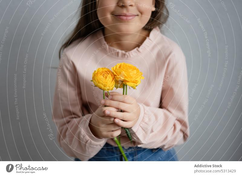 Crop girl standing with yellow buttercup flowers woman happy smile bloom glad floral fresh preteen cheerful bouquet positive plant blossom female casual joy