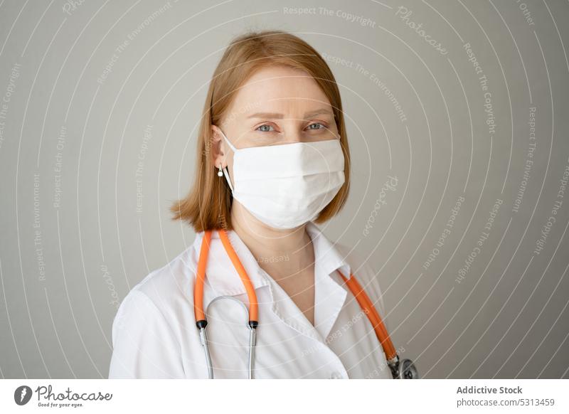 Woman in medical mask standing with stethoscope woman doctor uniform prevent caution portrait professional protect specialist health care clinic physician